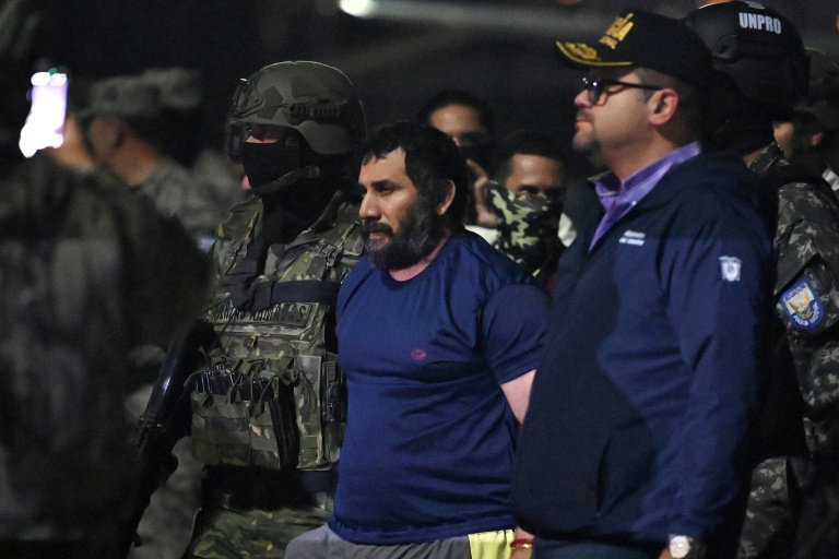 Le narcotrafiquant Adolfo Macias, alias Fito, encadré par le ministre équatorien de l'Intérieur John Reimberg (D) et des militaires, lors de son arrivée à Guayaquil après son arrestation, le 25 juin 2025