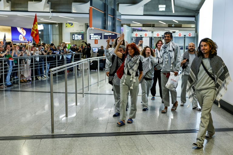 Des militants français, détenus et expulsés par Israël après l'interception de leur flottille à destination de Gaza, accueillis par des sympathisants à leur arrivée à l'aéroport Roissy Charles-de-Gaulle, près de Paris, le 22 mai 2026