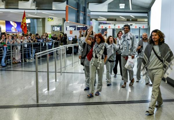 Des militants français, détenus et expulsés par Israël après l'interception de leur flottille à destination de Gaza, accueillis par des sympathisants à leur arrivée à l'aéroport Roissy Charles-de-Gaulle, près de Paris, le 22 mai 2026