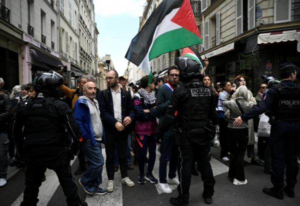 Le député La France Insoumise (LFI), Hadrien Clouet (c), des manifestants et des proches des militants français qui ont participé à la flottille pour Gaza  marchent vers l'Hôtel Matignon, lors d'un rassemblement à Paris, le 5 octobre 2025