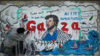 Un artiste peint une fresque dénonçant l'interception par Israël de la flottille pour Gaza, le 19 mai 2026 à Nousseirat, dans le centre de la Bande de Gaza