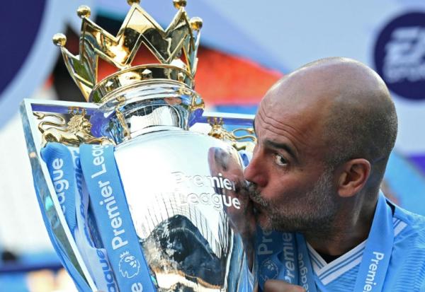 Pep Guardiola embrasse le trophée de la Premier League, le 19 mai 2024 à l'Etihad Stadium