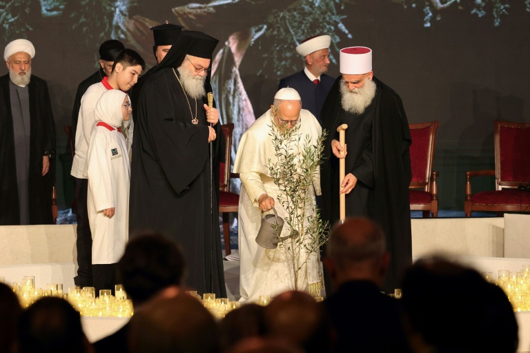 Le pape Léon XIV, entouré des dignitaires religieux libanais, arrose un olivier qu'il a planté dans le centre de Beyrouth, le 1er décembre 2025