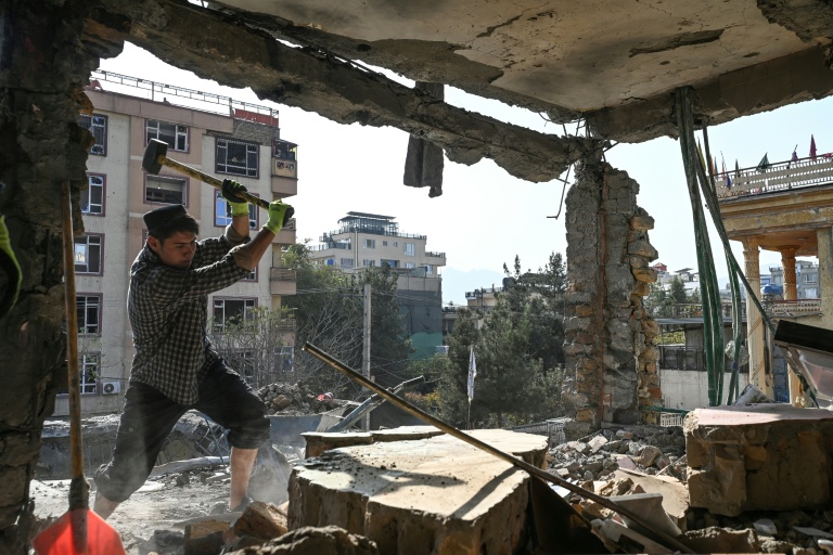 Un Afghan enlève des débris dans un logement endommagé lors d'une frappe aérienne, le 16 octobre 2025 à Kaboul