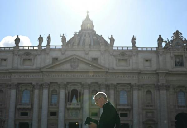 Un prélat passe devant la basilique Saint-Pierre à la veille du début du conclave, place Saint-Pierre au Vatican, le 6 mai 2025