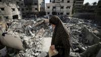 Une Palestinienne dans les décombres devant chez elle à Gaza, le 8 août 2022
