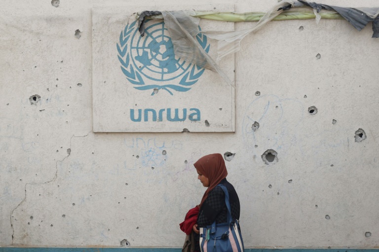 Le logo de l'Unrwa sur un mur criblé d'impacts dans un camp pour personnes déplacées à Rafah, dans le sud de la bande de GAza, le 28 mai 2024
