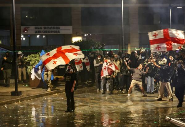 Des manifestants face à la police anti-émeute lors d'un rassemblement de l'opposition le jour des élections locales, le 4 octobre 2025 à Tbilissi, en Géorgie