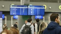 Des passagers devant un panneau d'information affichant de nombreux vols annulés, à l'aéroport de Thessalonique en Grèce le 4 janvier 2026