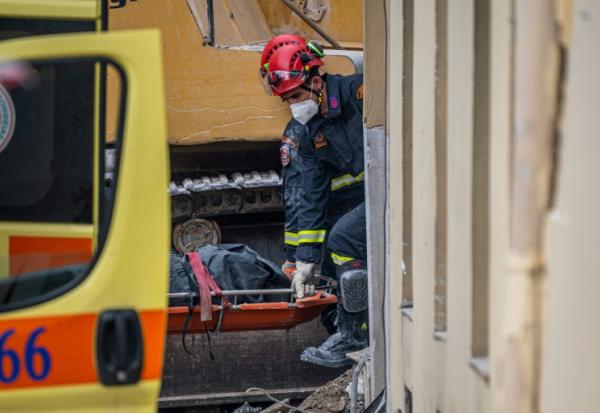 Des secouristes transportent le corps d'une personne retrouvée sous les décombres après l'effondrement d'un immeuble à Athènes, le 26 septembre 2026 