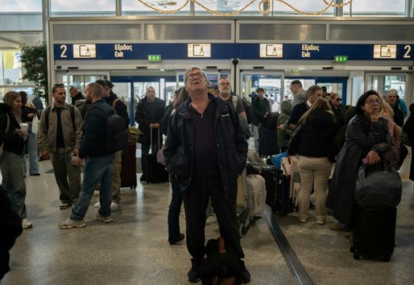 Des voyageurs attendent à l'aéroport d'Athènes-Spata après des retards et des reports de vols dans le pays dus à un "problème technique", le 4 janvier 2026
