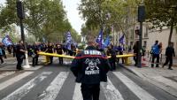 Un pompier portant une inscription "En grève" participe à une manifestation organisée par une large coalition de syndicats, à Paris, le 28 septembre 2026