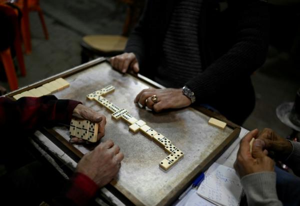 Des personnes jouent aux dominos à la terrasse d'un café avant la fermeture en application du couvre-feu, dans le centre-ville du Caire, le 2 avril 2026 en Egypte