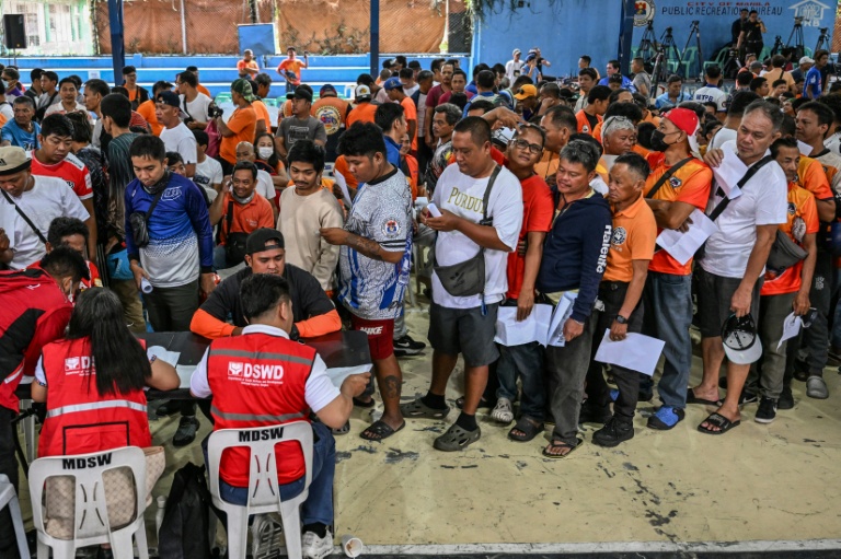Des conducteurs de tricycles font la queue pour la distribution d'une subvention sur le carburant à Manille, le 17 mars 2026 aux Philippines