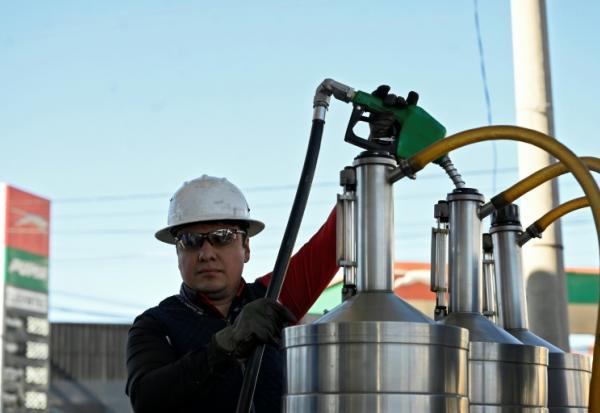 Un technicien du ministère de l'Energie et des Mines vérifie la qualité et les prix du carburant dans une station-service à Guatemala city le 10 mars 2026
