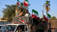 Des manifestants agitent des drapeaux iraniens à bord d'un véhicule, le 8 avril 2026 à Bagdad, en Irak