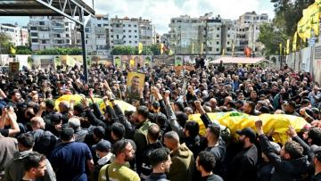 Des personnes en deuil portent les cercueils recouverts de drapeaux de membres du groupe militant Hezbollah soutenu par l’Iran, tués dans le sud du Liban, lors de leurs funérailles dans le quartier de Kafaat, dans la banlieue sud de Beyrouth, le 20 avril 2026
