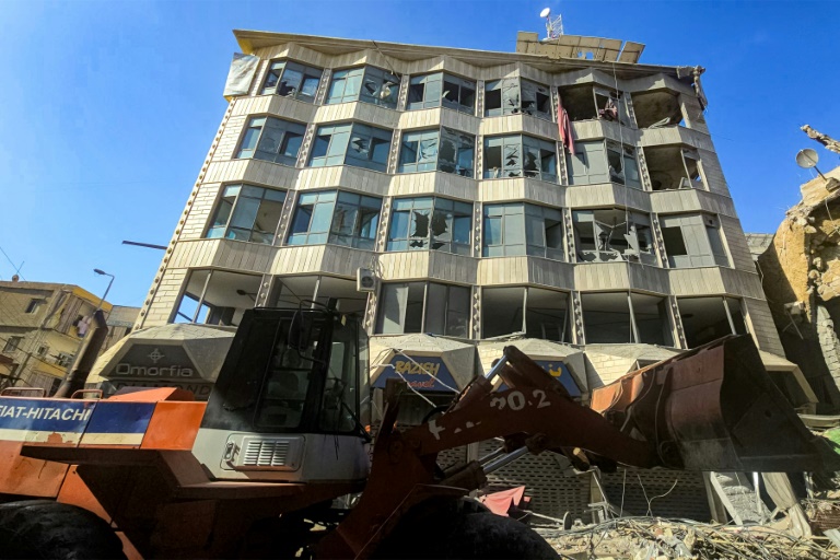 Un bulldozer déblaye des débris et gravats devant un bâtiment endommagé après des bombardements israéliens nocturnes sur la ville de Tyr, dans le sud du Liban, le 16 mai 2026