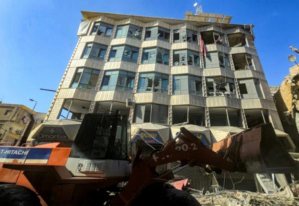 Un bulldozer déblaye des débris et gravats devant un bâtiment endommagé après des bombardements israéliens nocturnes sur la ville de Tyr, dans le sud du Liban, le 16 mai 2026