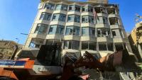 Un bulldozer déblaye des débris et gravats devant un bâtiment endommagé après des bombardements israéliens nocturnes sur la ville de Tyr, dans le sud du Liban, le 16 mai 2026