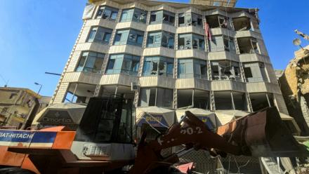 Un bulldozer déblaye des débris et gravats devant un bâtiment endommagé après des bombardements israéliens nocturnes sur la ville de Tyr, dans le sud du Liban, le 16 mai 2026