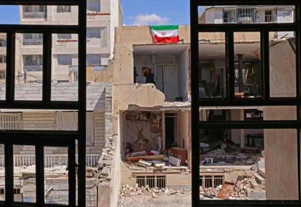 Un drapeau iranien sur un immeuble détruit  à Vahdat, au sud-ouest de Téhéran le 3 avril 2026