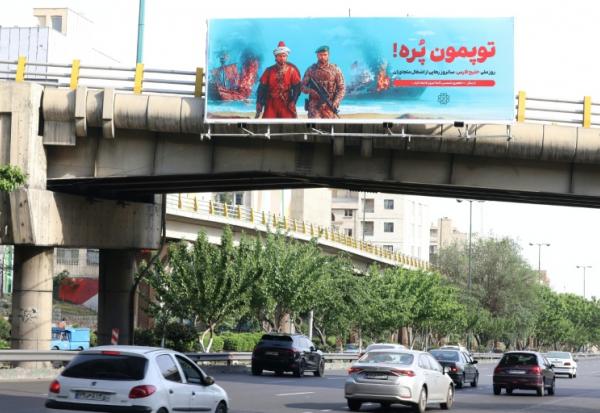 Une affiche anti-américaine sur laquelle est écrit en persan "Nos canons sont pleins" en référence au détroit d'Ormuz, déployée sur un pont au-dessus d'une autoroute à Téhéran, le 12 mai 2026