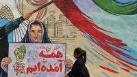 Une Iranienne passe devant une fresque anti-américaine et anti-israélienne sur laquelle on peut lire "Pour la révolution, nous sommes tous venus", dans la capitale Téhéran, le 10 mai 2026