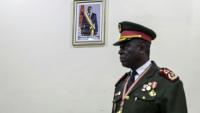 Le général Horta N'Tam devant une photo du président déchu de Guinée-Bissau Umaro Sissoco Embalo durant la cérémonie l'investissant comme dirigeant de la transition, à Bissau le 27 novembre 2025, au lendemain d'un coup d'Etat militaire