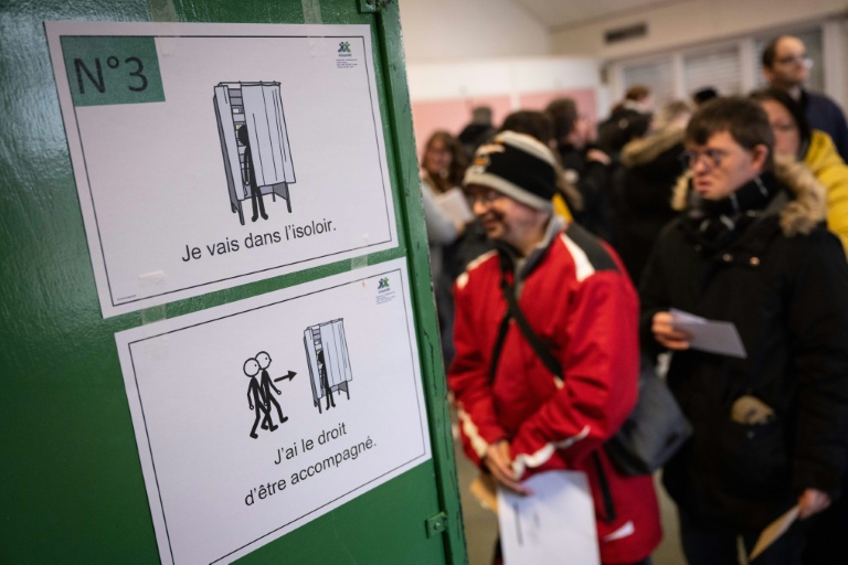 Des personnes en situation de handicap intellectuel patientent avant d'entrer dans un isoloir lors d'un faux scrutin organisé le 17 février 2026 à Saint-Dié-des-Vosges