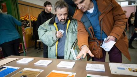 Un éducateur explique les règles pour voter lors d'un faux scrutin organisé pour des personnes en situation de handicap intellectuel, le 17 février 2026 à  Saint-Dié-des-Vosges