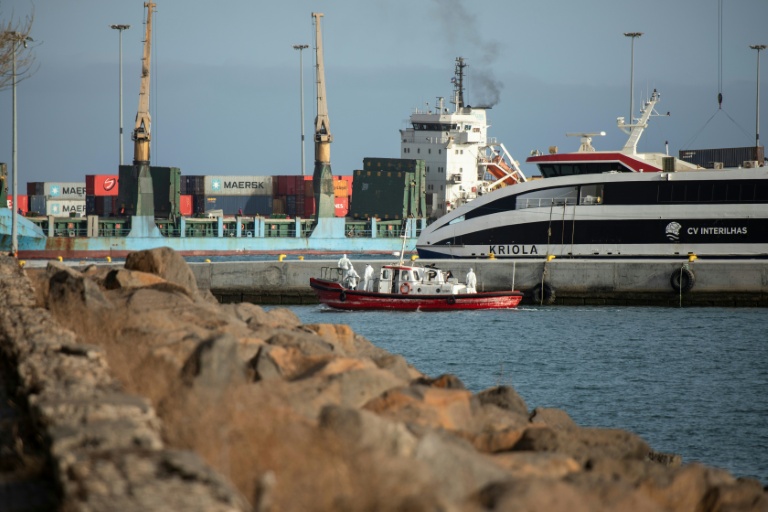 Un bateau-ambulance transportant des membres d'équipage en combinaisons de protection  retourne au port de Praia, après une visite à bord du bateau de croisière MV Hondius, au mouillage au large du port, le 5 mai 2026 au Cap-Vert