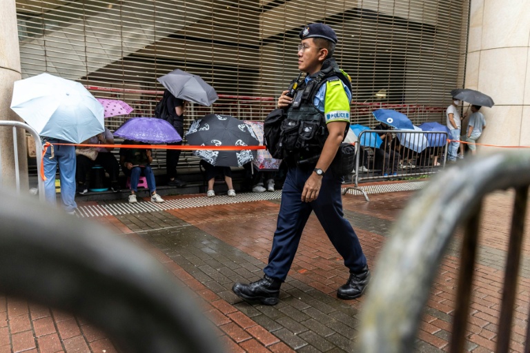Un policier en patrouille devant la Cour de West Kowloon, à Hong Kong,  avant l'arrivée de Jimmy Lai pour son procès, le 18 août 2025