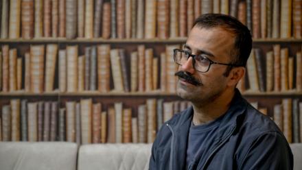 Farhad Sheikhi, un Kurde iranien qui a rejoint les manifestations antigouvernementales en 2022, montre des images des manifestations en Iran lors d'une interview à Souleimaniyeh, le 12 mars 2026 en Irak