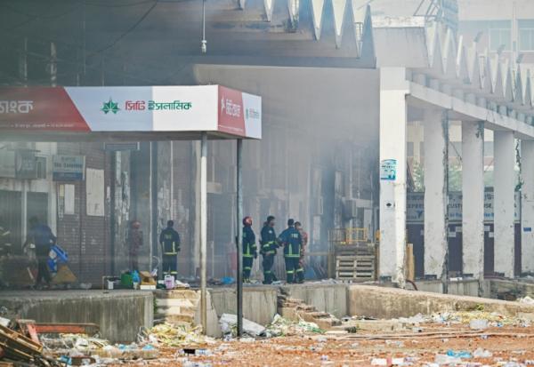 Des pompiers inspectent le terminal de fret de l'aéroport international Hazrat Shahjalal de Dacca au Bangladesh, le 19 octobre 2025, au lendemain de l'incendie qui l'a ravagé