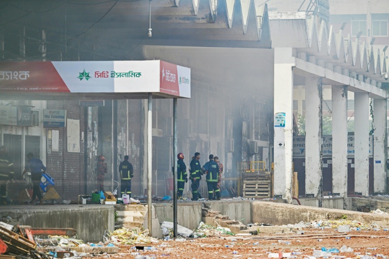 Des pompiers inspectent le terminal de fret de l'aéroport international Hazrat Shahjalal de Dacca au Bangladesh, le 19 octobre 2025, au lendemain de l'incendie qui l'a ravagé
