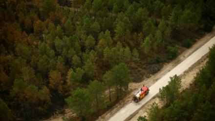 Vue aérienne depuis un hélicoptère de la sécurité civile montrant un camion de pompiers sur une route à Le Porge, en Gironde, le 31 juillet 2026