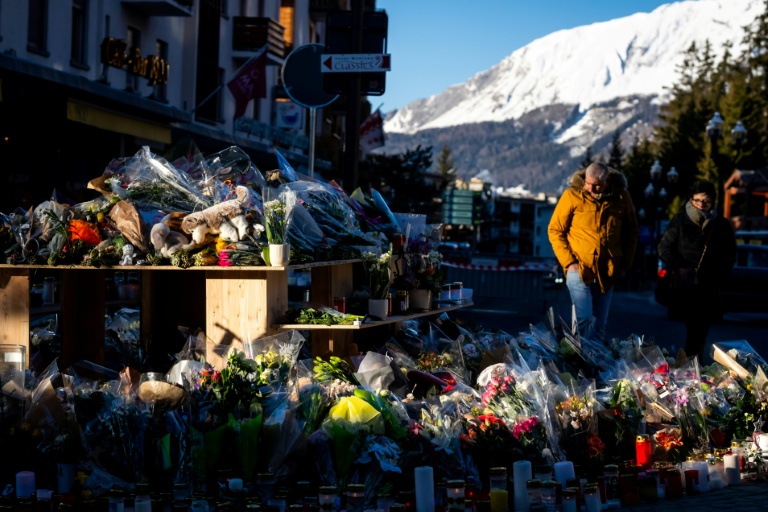 Des fleurs déposées près du bar Le Constellation à Crans-Montana, en Suisse, en hommage aux victimes de l'incendie, le 4 janvier 2026 