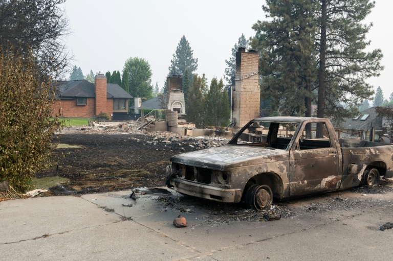 Une voiture calcinée devant les ruines d'une maison rasée par les flammes, à Spokane, dans l'Etat de Washington, le 2 août 2026