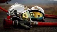 Deux casques de pompier et une lance à incendie gisent au sol alors qu'un incendie de forêt fait rage à Saint-Jean-d'Illac, à environ 30 km de Bordeaux, le 26 juillet 2026