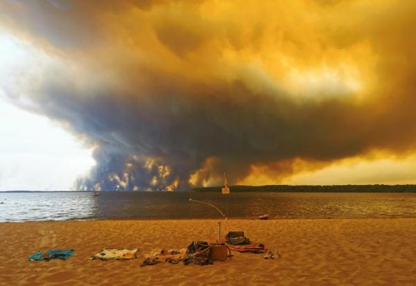 Vue d'un épais nuage de fumée dû aux feux de forêts depuis la plage du Moutchic sur le lac de Lacanau, en Gironde, le 24 juillet 2026