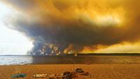 Vue d'un épais nuage de fumée dû aux feux de forêts depuis la plage du Moutchic sur le lac de Lacanau, en Gironde, le 24 juillet 2026