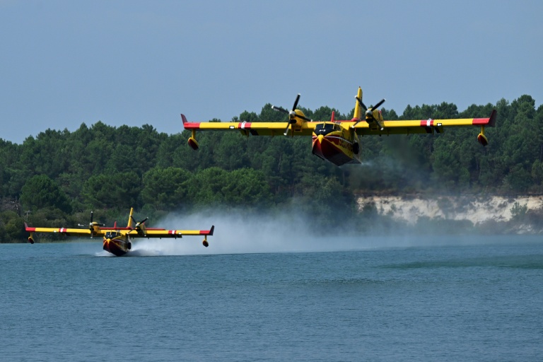 Deux Canadair se rechargent en eau le 15 août 2026 sur un des lacs de la réserve naturelle d'Arjuzanx pour lutter contre l'incendie de Luglon, dans la forêt des Landes