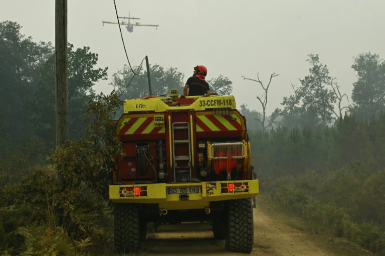 Un camion pompier survolé par un appui aérien le 15 août 2026 dans la forêt des Landes en flammes près de Luglon