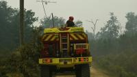 Un camion pompier survolé par un appui aérien le 15 août 2026 dans la forêt des Landes en flammes près de Luglon