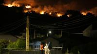 Des habitants observent les flammes sur les crêtes des collines tandis que les pompiers luttent contre un incendie de forêt dans la région de Cebreros, près d’Ávila, à 80 km à l’ouest de Madrid, dans la nuit du 24 juillet 2026