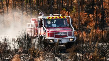 Un camion de pompiers au milieu d'une végétation en partie détruite par un incendie à Lège-Cap-Ferret, en Gironde, le 1er août 2026 