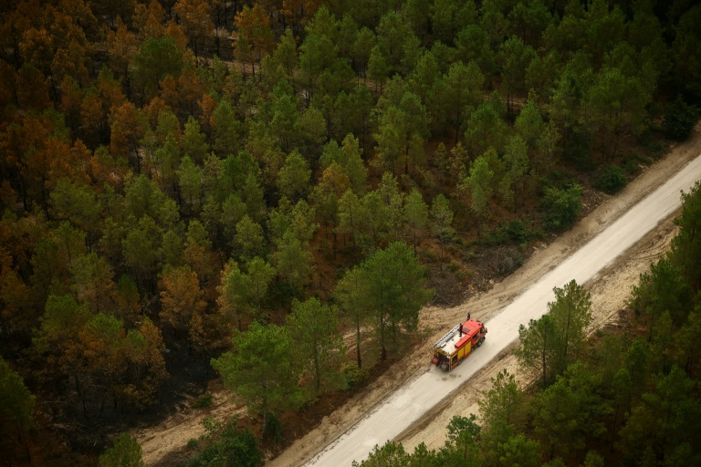 Vue aérienne depuis un hélicoptère de la Sécurité civile montrant un camion de pompiers sur une route du Porge, en Gironde, le 31 juillet 2026