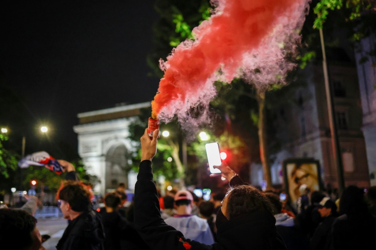 Des supporteurs du Paris Saint-Germain célèbrent la victoire après la qualification de leur équipe en finale de la Ligue des champions face au Bayern Munich, près de l'arc de Triomphe, le 6 mai 2026, à Paris