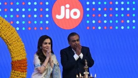 Le milliardaire indien et président de Reliance Industries, Mukesh Ambani (d), et son épouse Nita Ambani, saluent l'assistance lors de l'introduction en bourse de Jio Platforms à la Bourse de Bombay, le 28 octobre 2026 en Inde